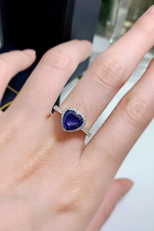 2 carat blue heart moissanite ring in platinum-plated sterling silver with pavé side stones on a hand