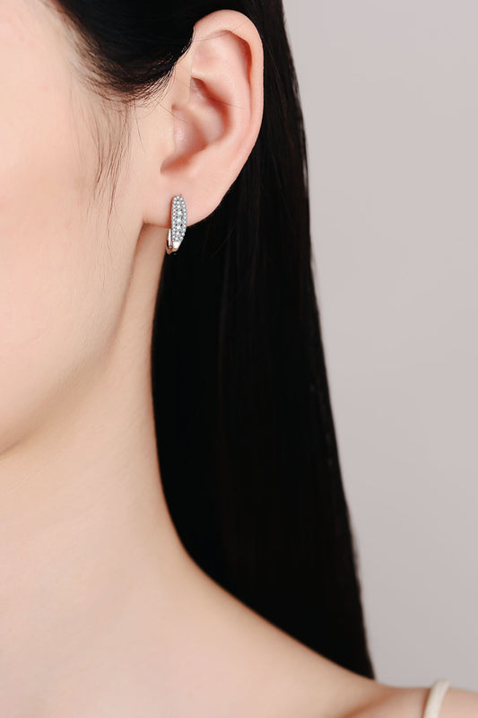 A woman wearing the Pavé moissanite hoop earrings in rhodium-plated sterling silver by MerchLuxx.