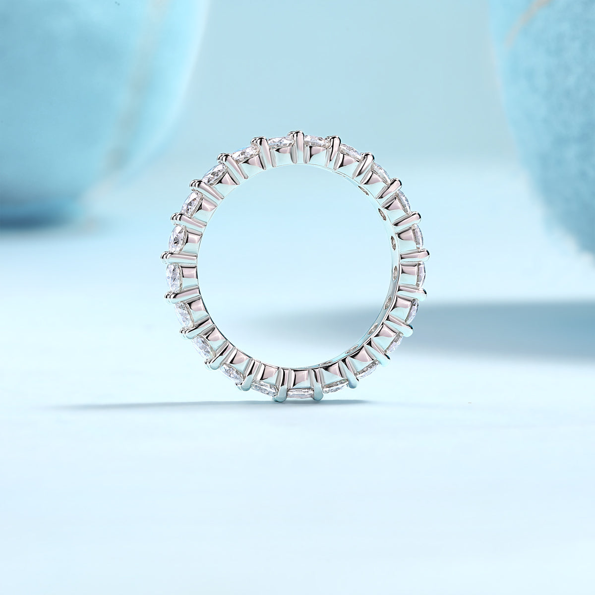 Eternaé moissanite full eternity band in S925 sterling silver continuous round stone ring by MerchLuxx on a light blue background