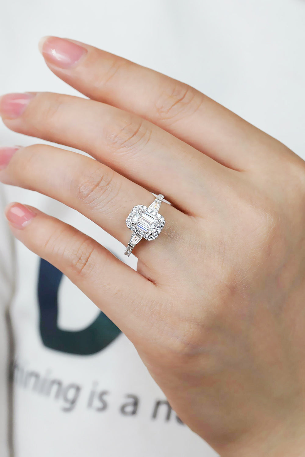 Virella emerald-cut moissanite halo ring in platinum-plated sterling silver by MerchLuxx