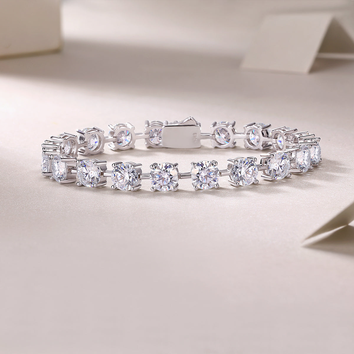 Tempéra moissanite tennis bracelet in S925 sterling silver with round brilliant stones, luxury jewelry by MerchLuxx on a light background