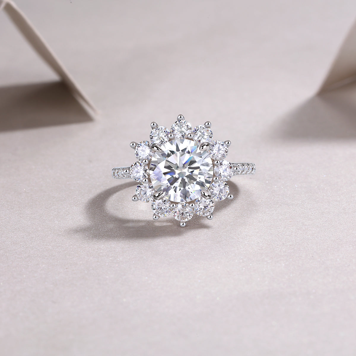 Soléa 3 carat moissanite floral halo ring in platinum-plated sterling silver statement engagement ring by MerchLuxx on a light pink background