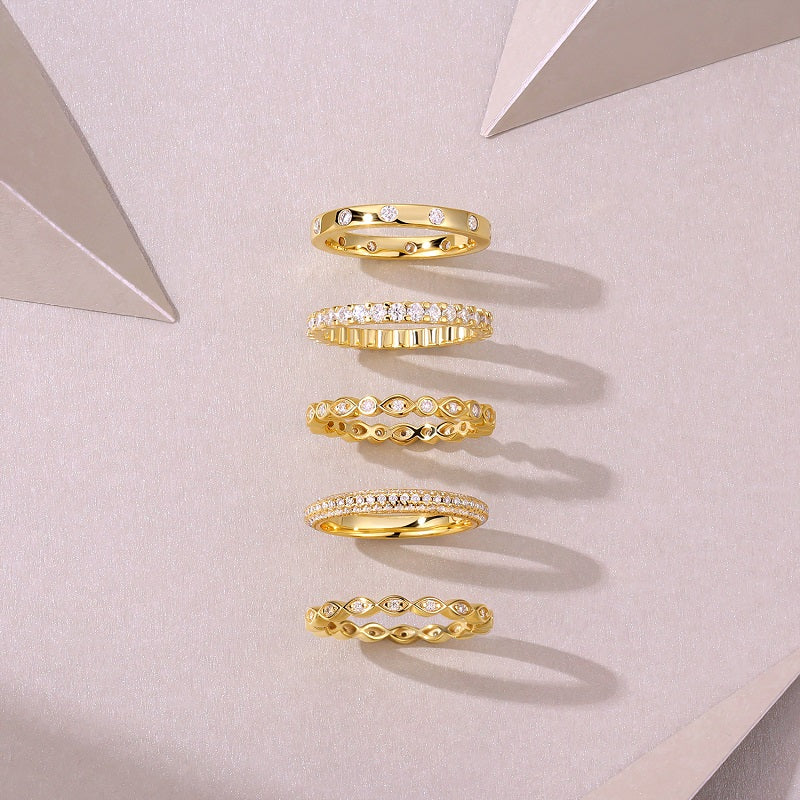Set of Aurielle moissanite stackable ring set in 18K gold-plated sterling silver layered luxury bands by MerchLuxx on a light gray background