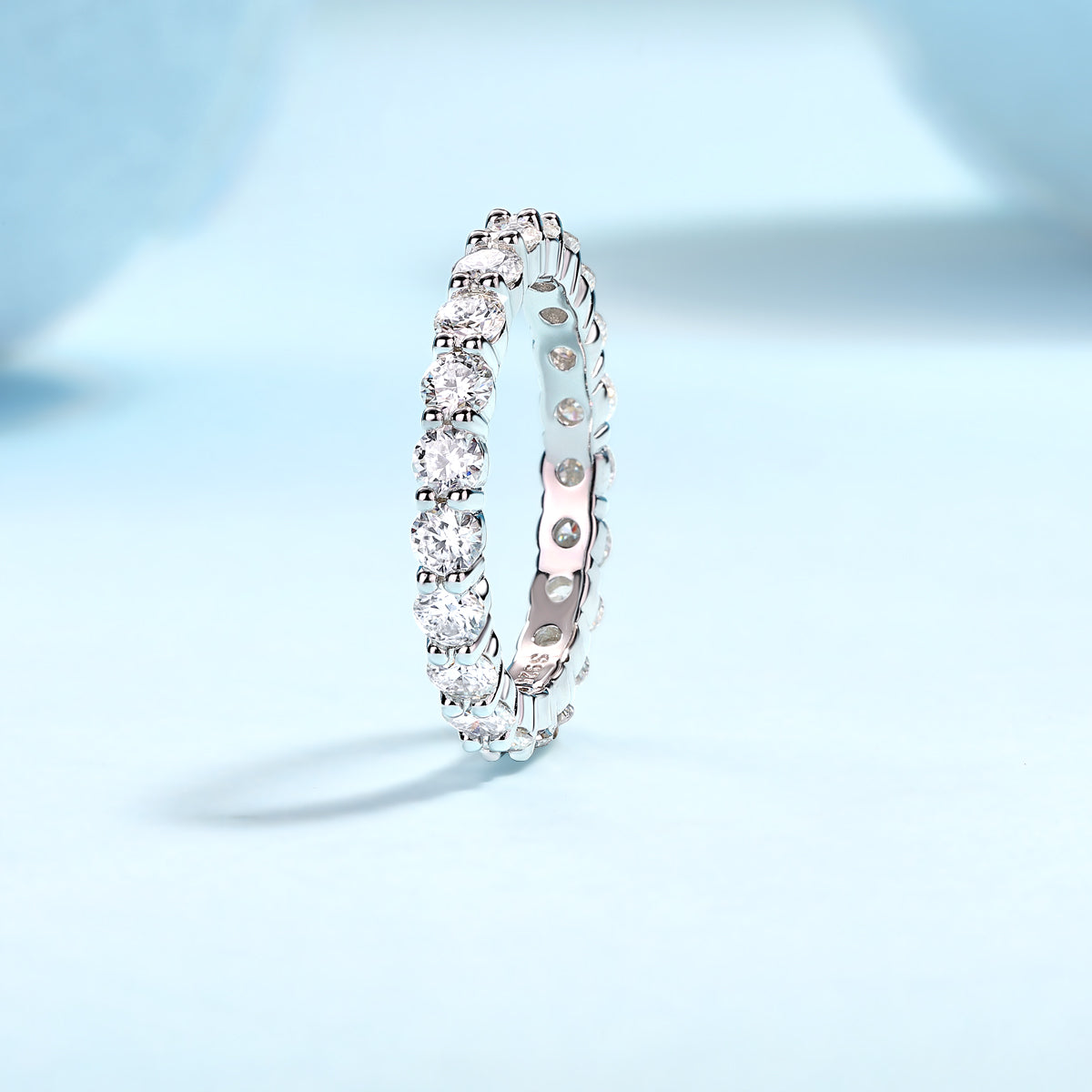 Eternaé moissanite full eternity band in S925 sterling silver continuous round stone ring by MerchLuxx on a light blue background