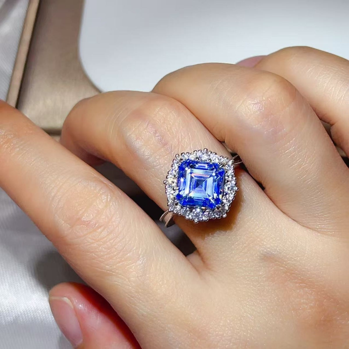 Woman wearing the Sapphire™ Blue Halo Ring on her finger