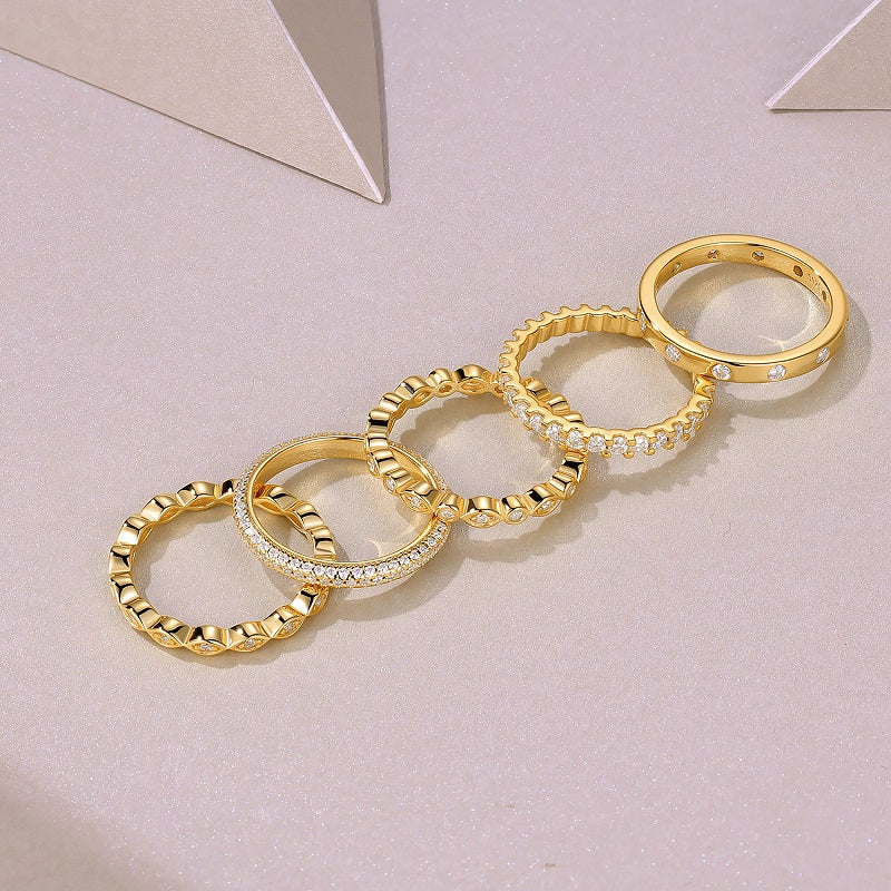 Set of  Aurielle moissanite stackable ring set in 18K gold-plated sterling silver layered luxury bands by MerchLuxx  on a light pink background
