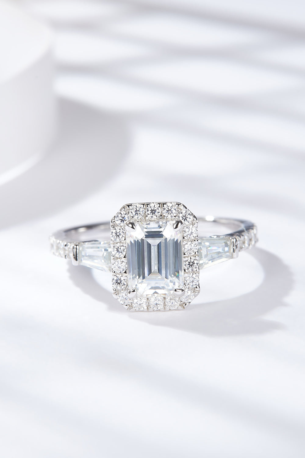 Virella emerald-cut moissanite halo ring in platinum-plated sterling silver by MerchLuxx