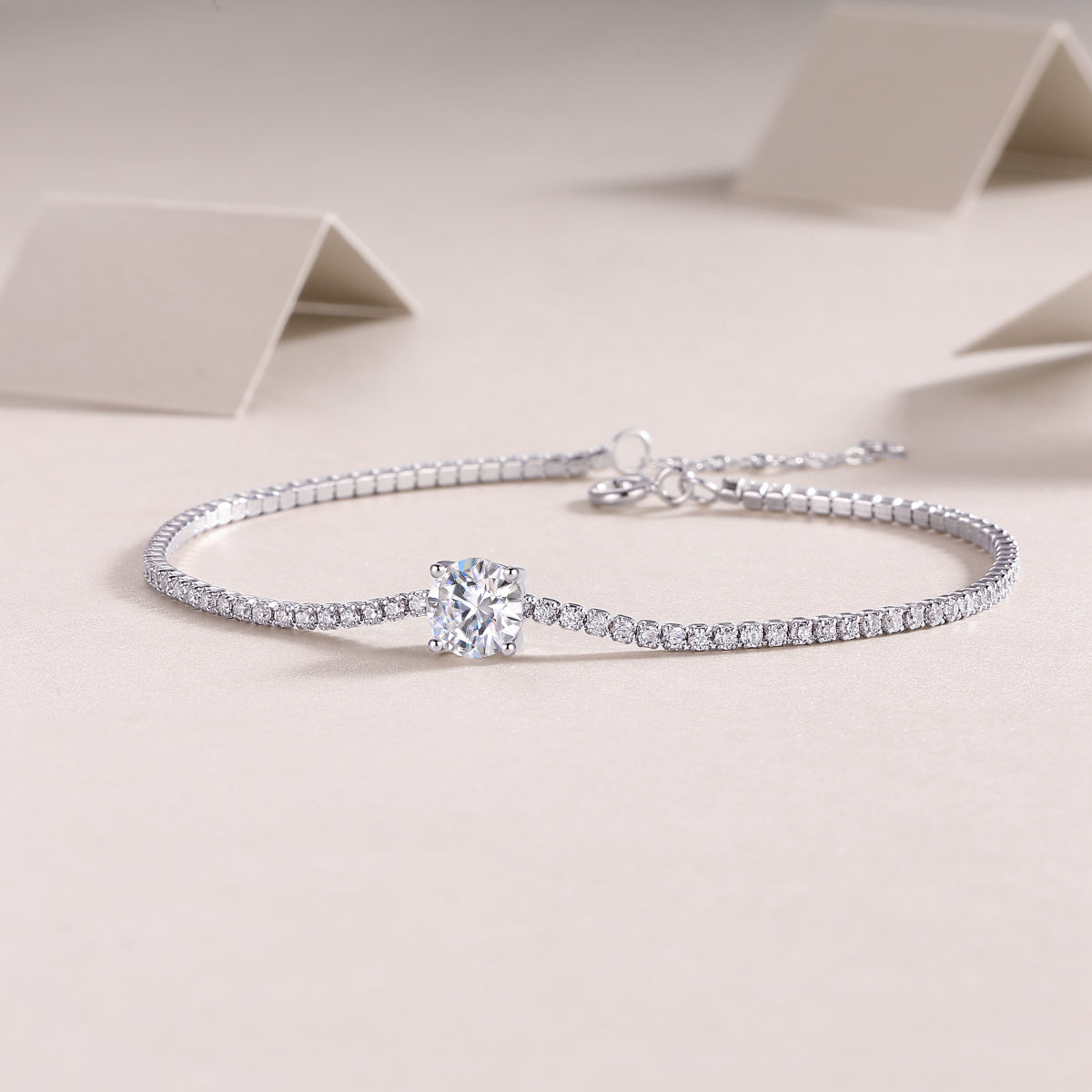 Écloria 1 carat moissanite tennis bracelet in S925 sterling silver, delicate luxury wrist jewelry by MerchLuxx on a beige background