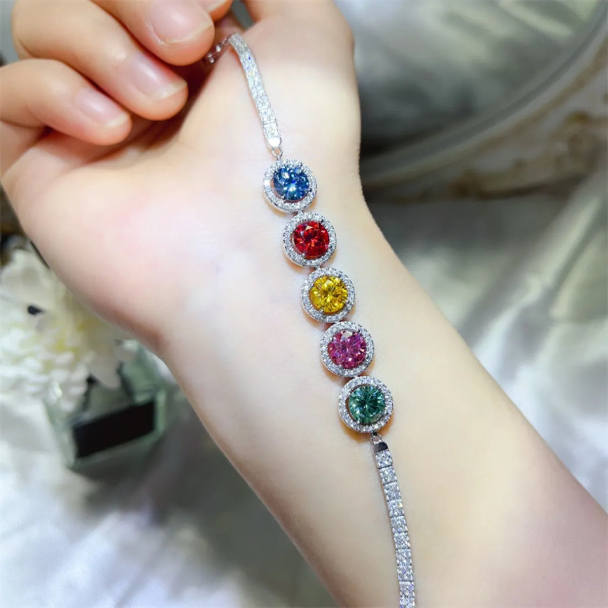 5-carat multicolor moissanite bracelet in sterling silver on the wrist with a blurred background
