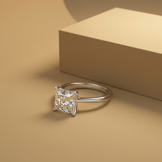 Aurelis™ 5 carat moissanite solitaire ring in platinum-plated 925 sterling silver with minimalist prong setting on a beige background
