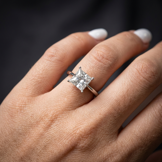 Aurelis™ 5 carat moissanite solitaire ring in platinum-plated 925 sterling silver with minimalist prong setting worn an a womans hand