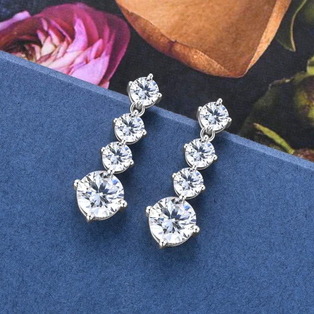Celestia™ Moissanite Drop Earrings on blue jewelry display