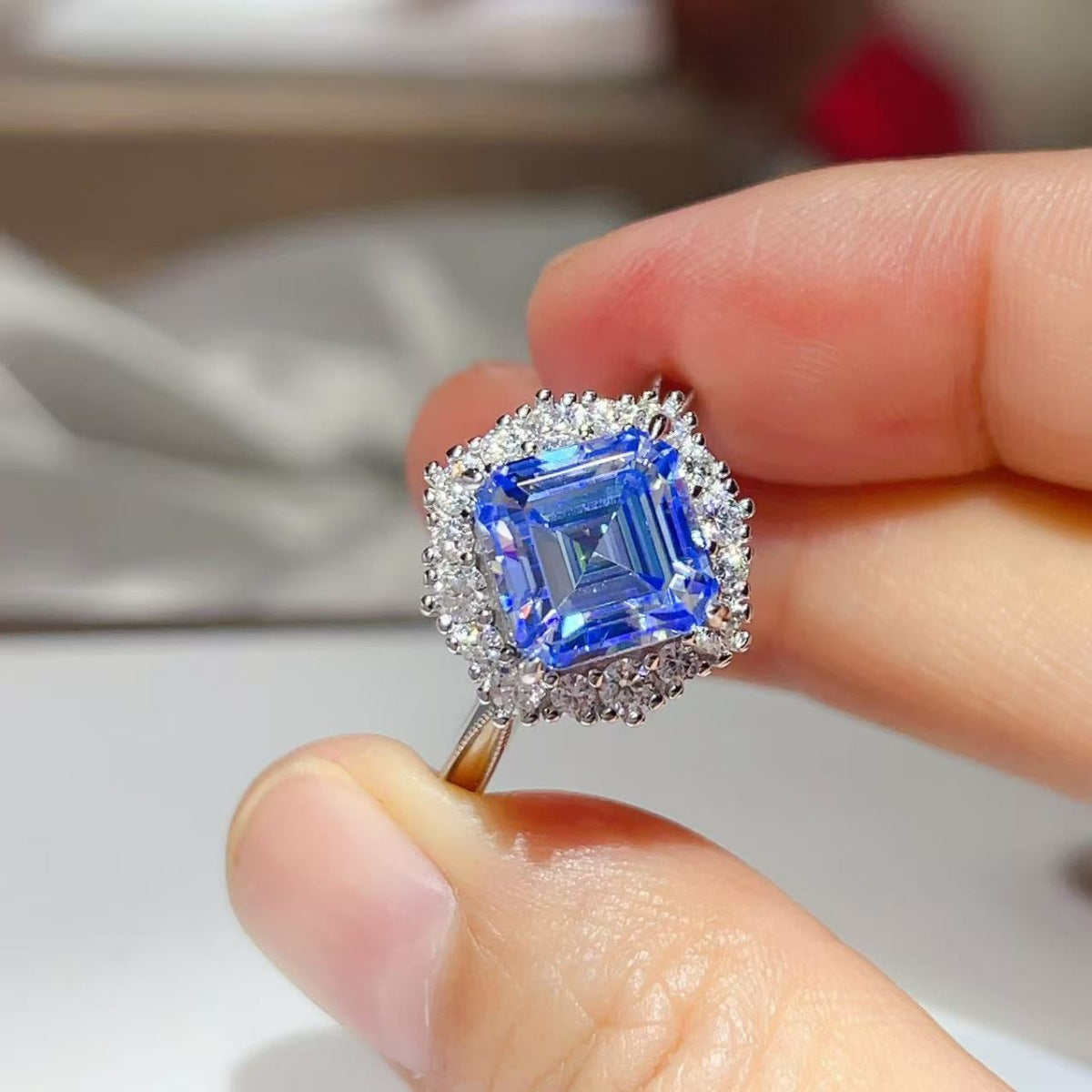 Close-up of the Sapphire™ Blue Halo Ring held between fingers