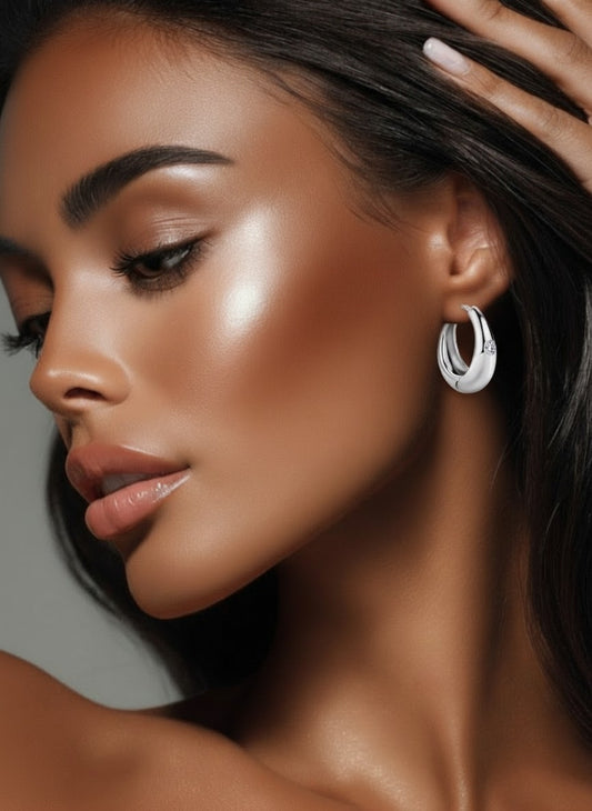 Close-up of a woman wearing 0.12ct moissanite channel hoop earrings in sterling silver with platinum plating