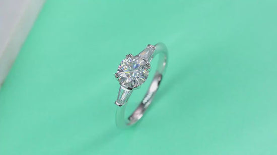 A video showing the sparkle of the Virella 1 carat moissanite three-stone ring in S925 sterling silver with baguette side stones, luxury engagement ring by MerchLuxx 