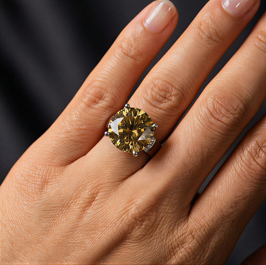 Close-up of a hand wearing the Aurelion 20-carat golden moissanite ring in sterling silver by MerchLuxx, against a dark background